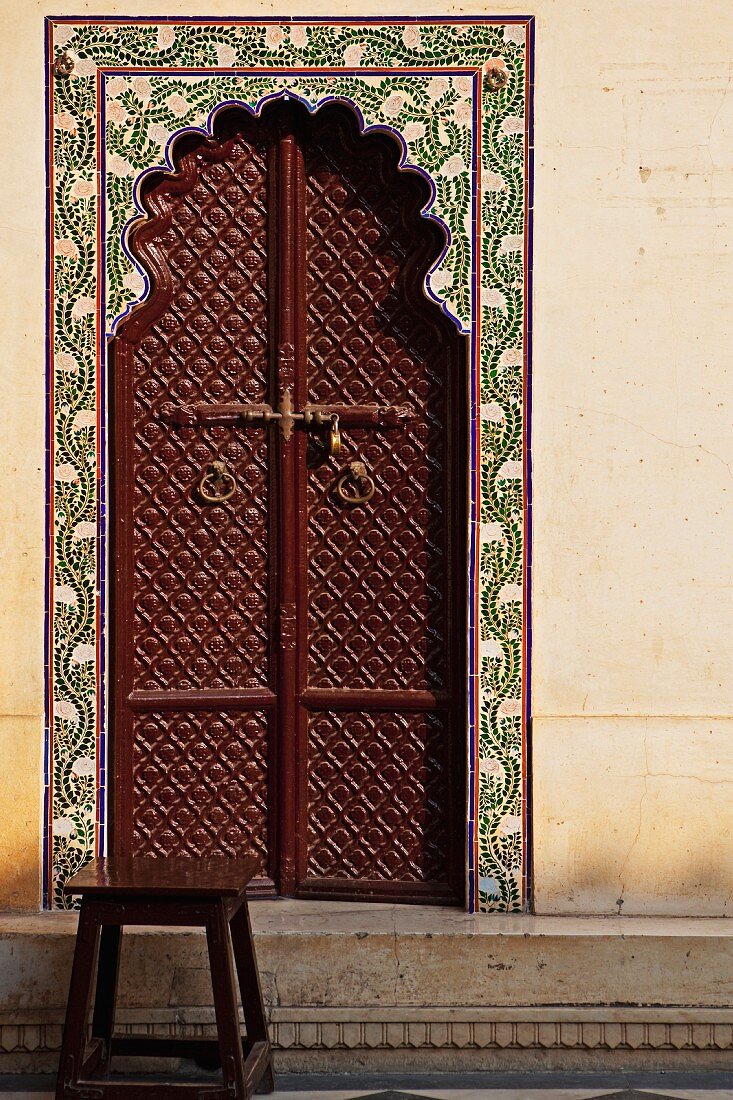 Mit Ornamenten dekorierte, braune Tür eines indischen Palastes