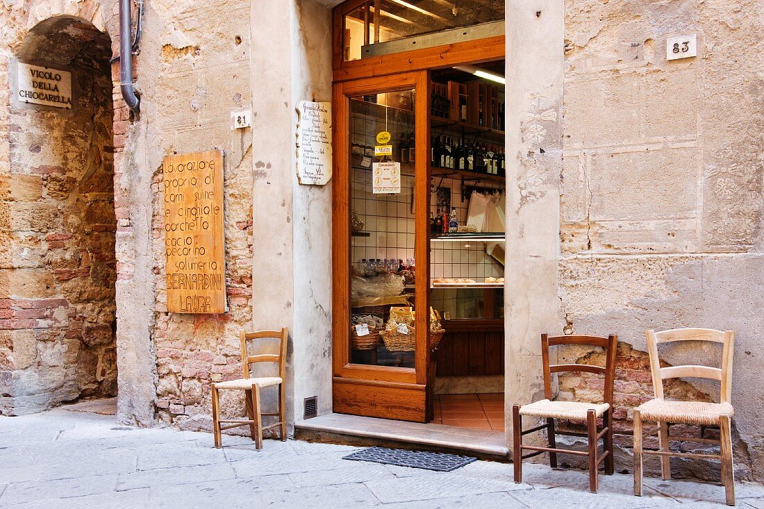 Italienische Metzgerei; vor der Tür drei alte Stühle