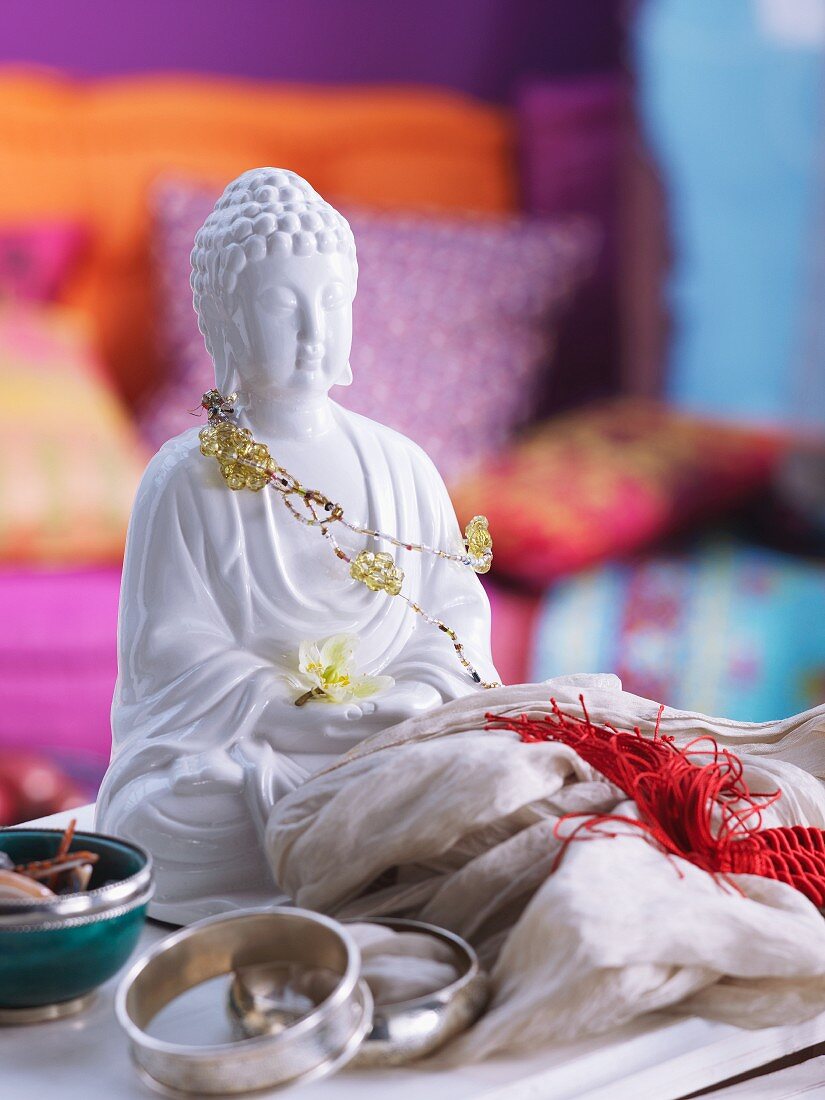 Mit Schmuck und Seidentuch dekorierte weiße Buddhafigur