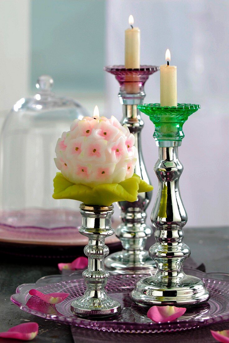 Kerzenständer aus Bauernsilber mit brennenden Kerzen auf Glasschale