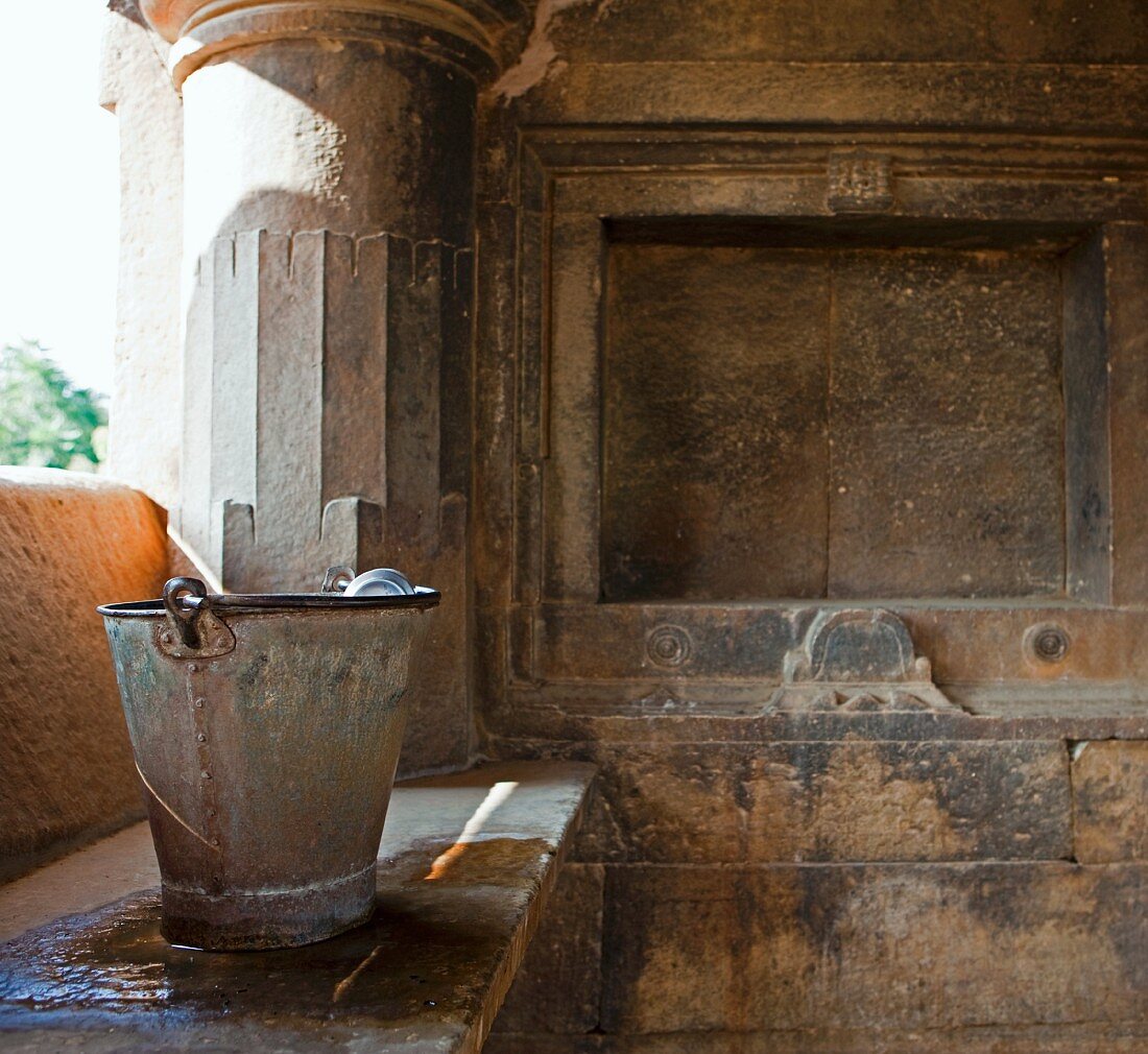 Wassereimer auf Steinbank in Sas-Bahu Tempel (Indien)