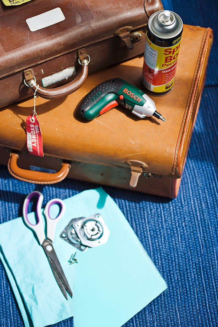 Utensils for converting old suitcases (leather suitcases, cordless screwdriver, spray glue, scissors and screws)
