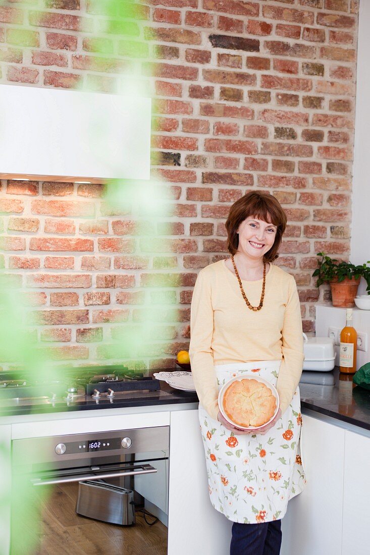 woman in kitchen smiling at viewer