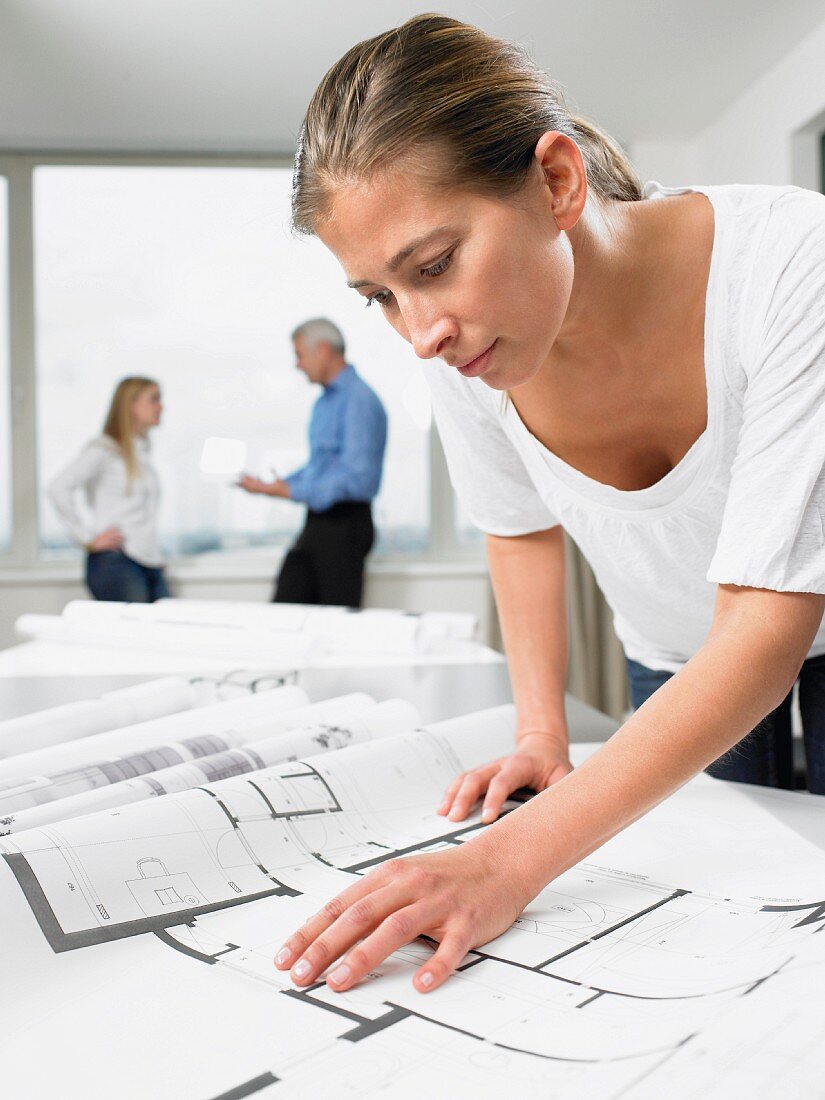 Woman working on blue prints