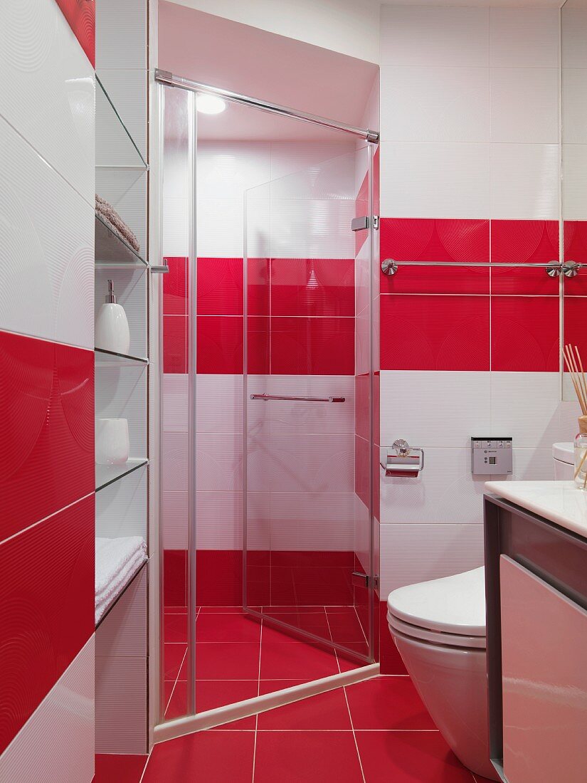 Designer bathroom in red and white with glass shower stall