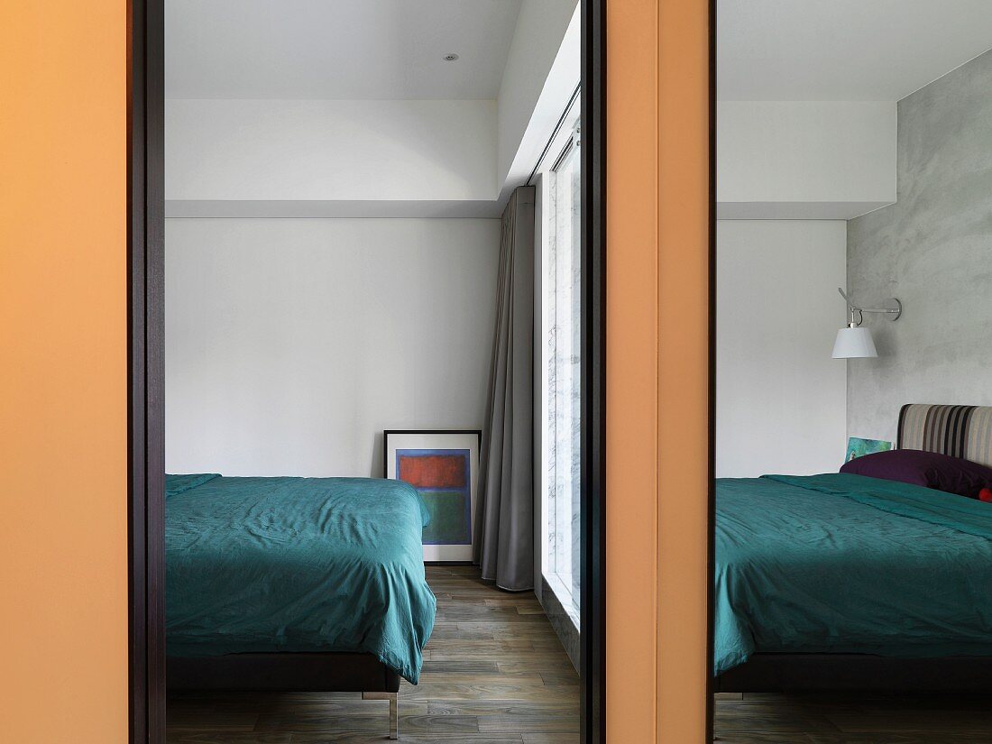 Blick ins Schlafzimmer auf das Fußende eines modernen Doppelbettes
