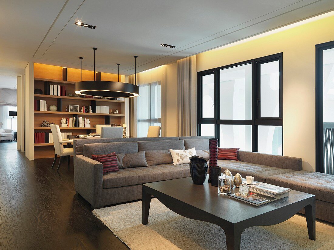 Indirekte Beleuchtung und dunkler Dielenboden erzeugen in dem eleganten Wohnzimmer Behaglichkeit