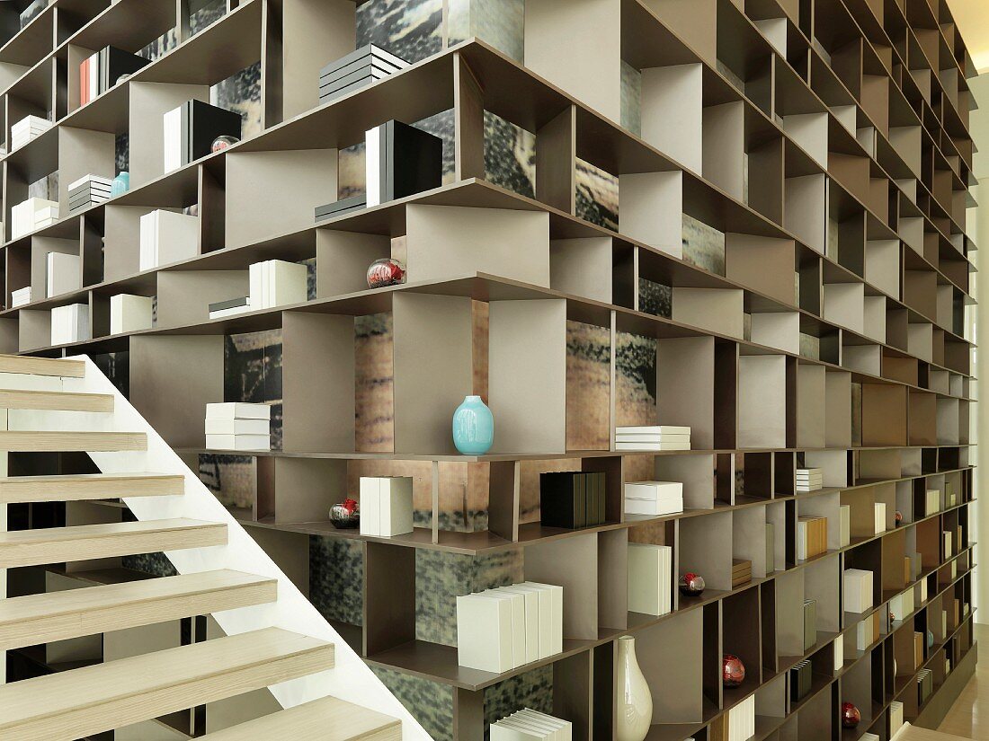 Staircase along floor to ceiling shelving unit