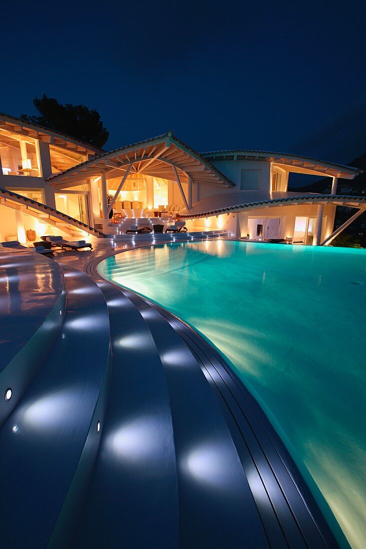 Beleuchtete Stufen führen von der Terrasse zum Pool einer modernen, spanischen Villa