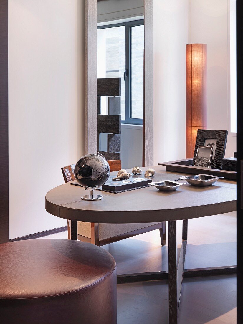 Ovaler Esstisch mit gepolstertem Hocker in modernem Wohnraum