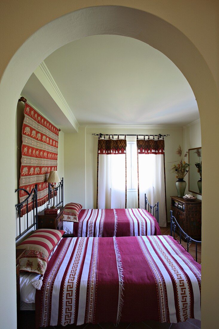Schlafzimmer mit zwei Einzelbetten aus Gusseisen mit gestreifter Bettwäsche (Villa Octavius, Lefkas, Griechenland)
