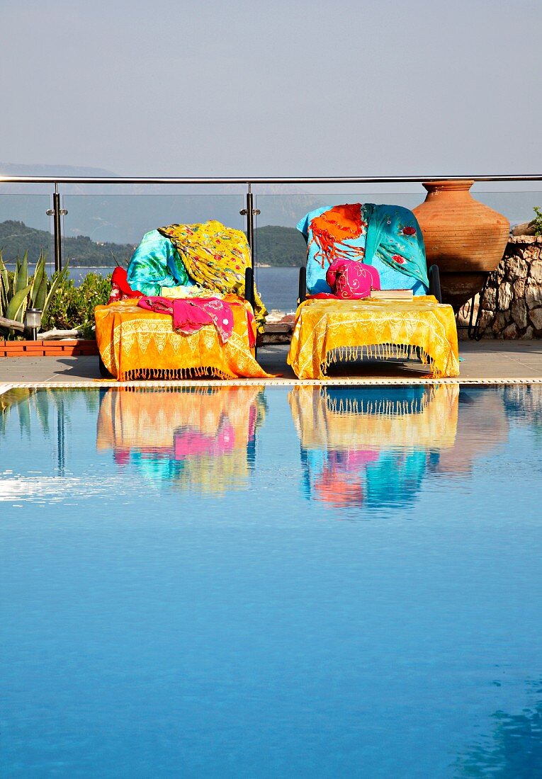 Ruheliegen mit bunten Badetüchern am Swimmingpool auf der Terrasse (Villa Octavius, Lefkas, Griechenland)