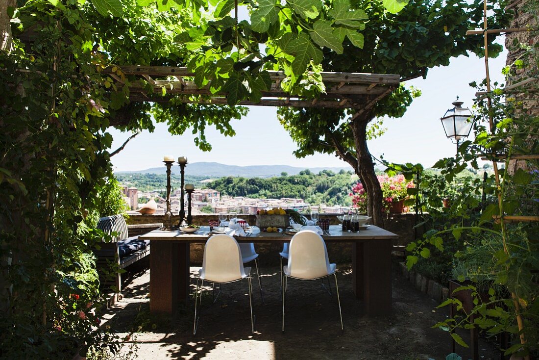 Gedeckter Tisch auf rustikaler Terrasse mit Blick auf die Landschaft