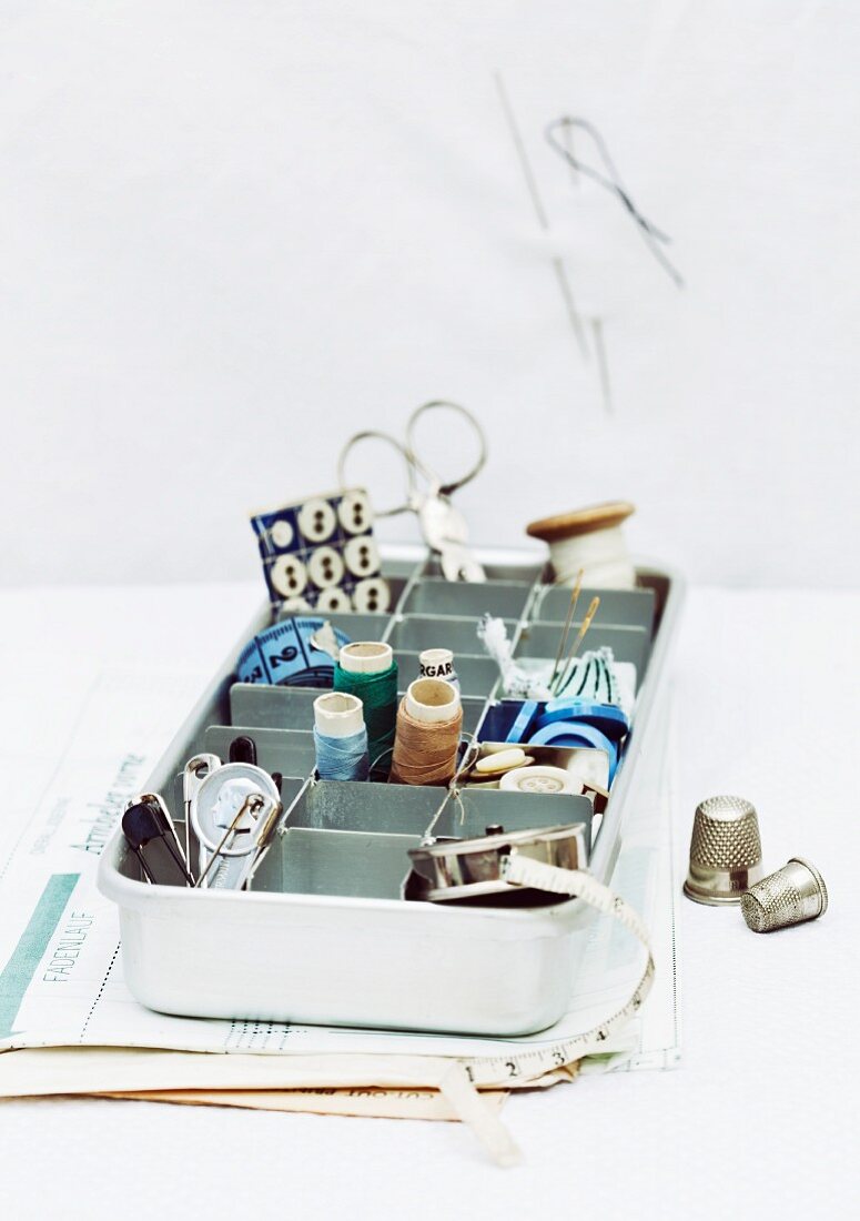 Ice cube try used for organised storage of sewing utensils