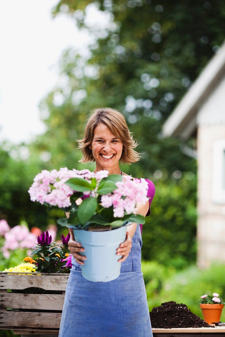 woman offering a bucket of flowers