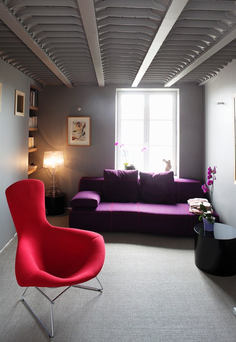 Moderner Wohnraum mit Sessel und Sofa im Designerstil und ausgefallener Deckenarchitektur