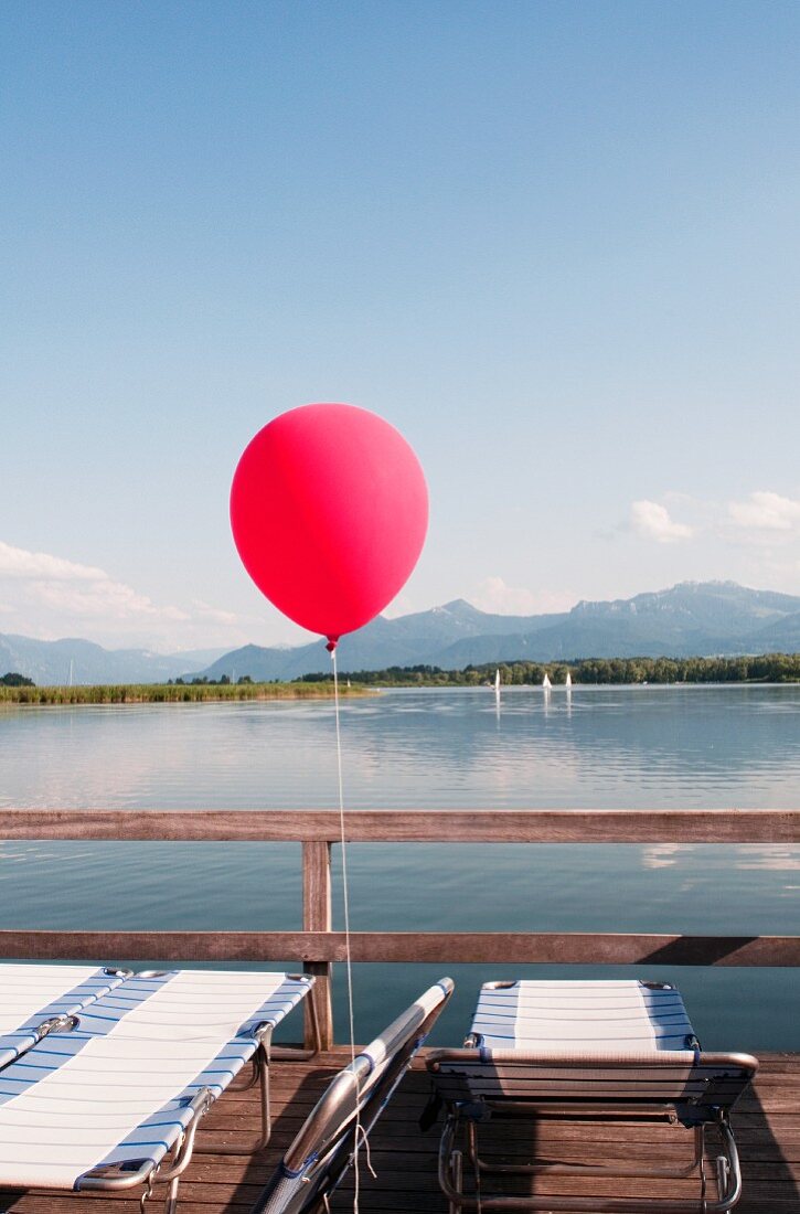 Balloon and recliners next to lake