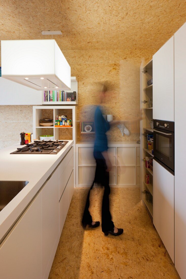 weiße Designerküche mit Mittelblock in spanplattenverkleidetem Raum