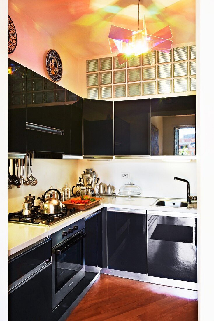Schwarze Hochglanzküche mit Glasbaustein-Oberlicht und zeitgenössischer Designerlampe