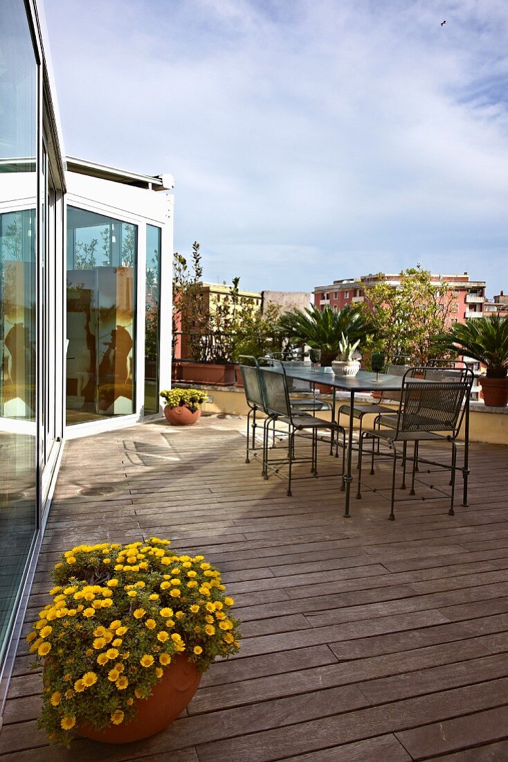 Delicate garden furniture on large roof terrace with wooden flooring