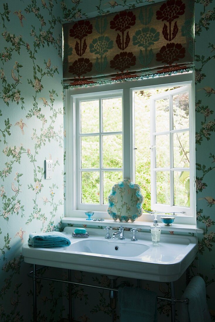 Vintage Waschtisch in Badezimmerecke am Fenster und Blumentapete an Wand