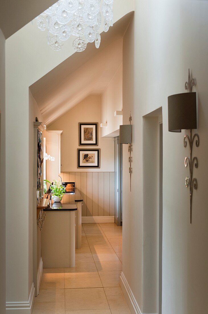 Gangbereich mit Tageslichteinfall und Blick auf Kücheneinbau in offenem Dachgeschoss im eleganten Landhausstil.