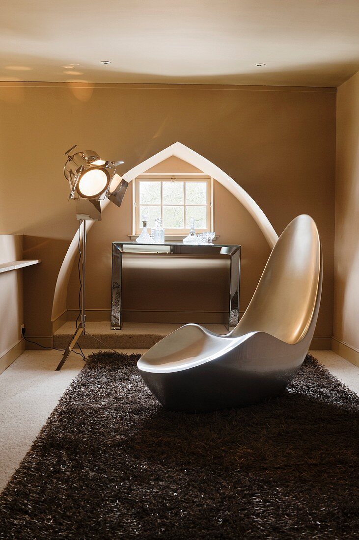 Designer chair in front of window niche shaped like a Reuleaux triangle