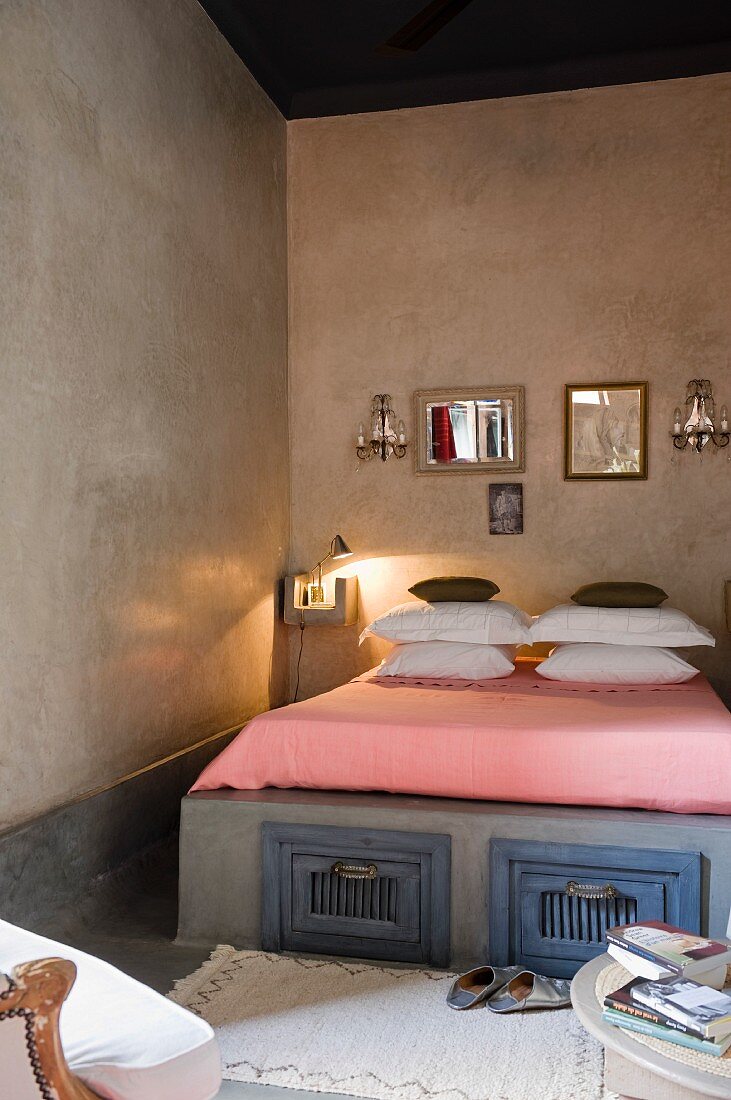 Spiegelsammlung über Doppelbett mit aufgetürmten Kissen und originellen Unterbettkommoden