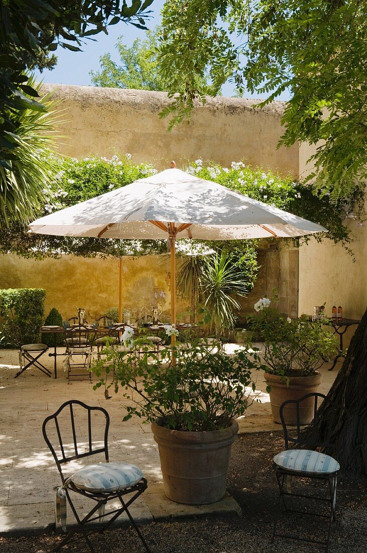 Parasol and seating area in grounds of Provence country house