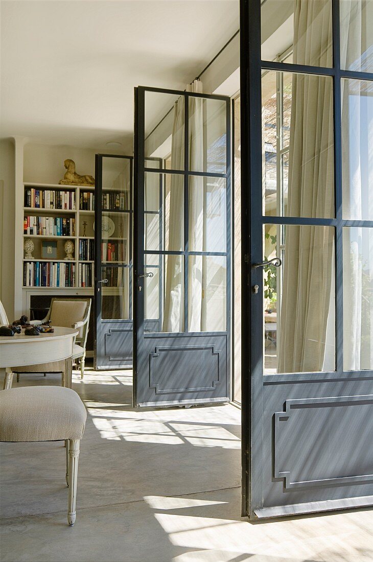 Geöffnete Terrassentüren im Wohnzimmer eines provenzalischen Landhauses