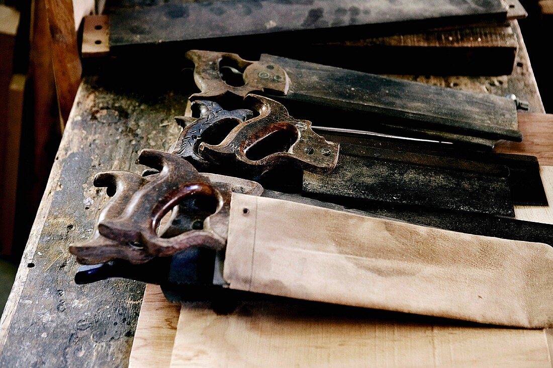 Altes Werkzeug auf rustikalem Holztisch liegend