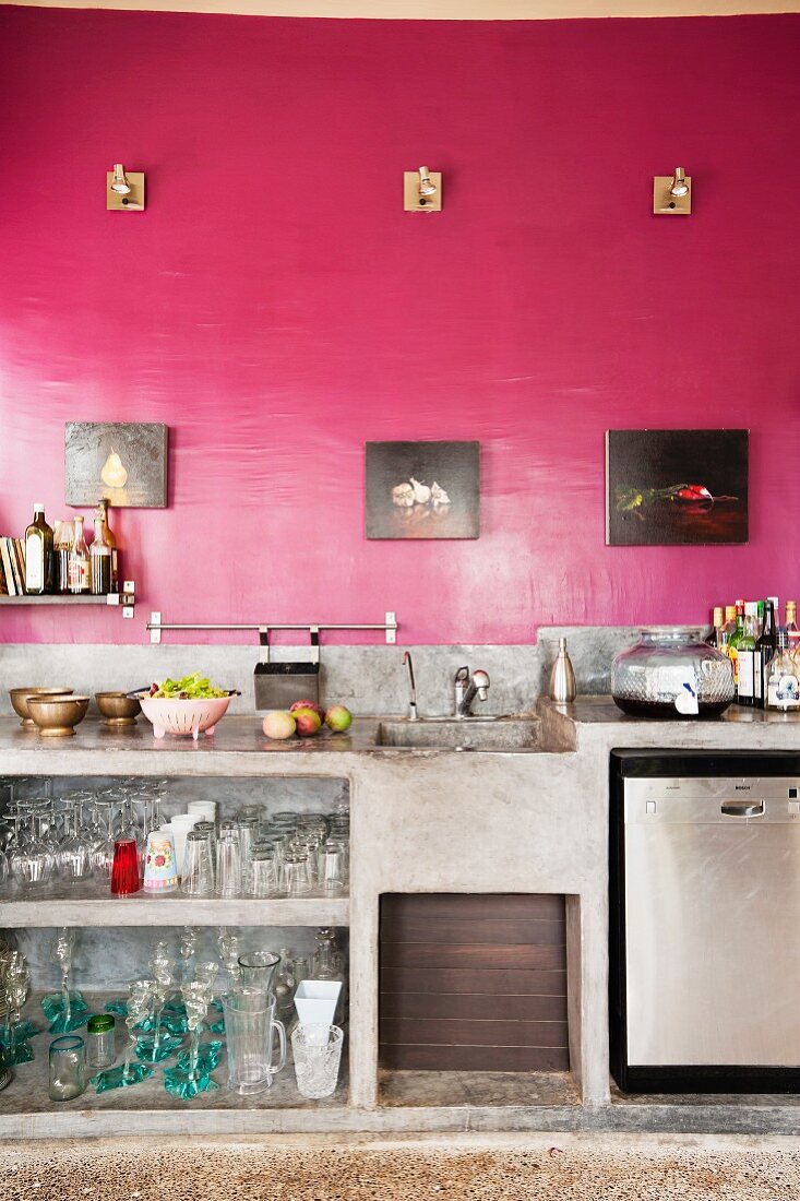 Wandansicht einer Küchenzeile in Betonausführung mit rot gestalteter Wand
