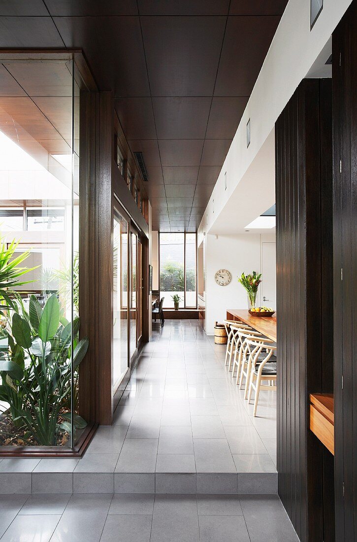 View from hallway into open-plan dining room of contemporary house with patio