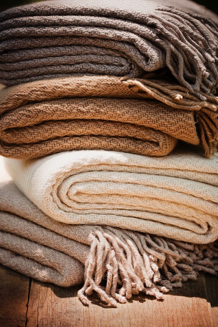 Gestapelte Wolldecken in verschiedenen Naturfarben