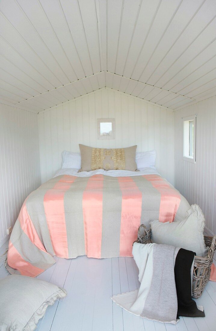 Schlafzimmer mit weisser Holzverkleidung an Wand und Decke in kleinem Häuschen