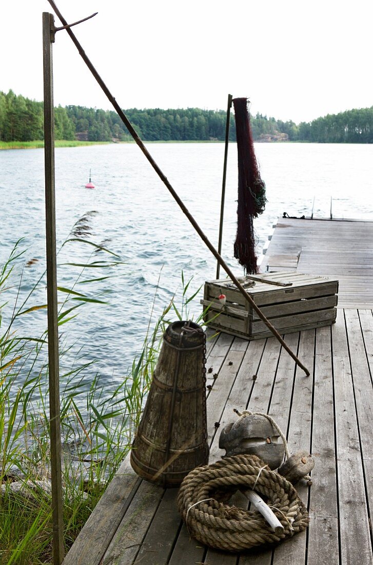 Alter Holzsteg mit Fischereiutensilien an idyllischem See