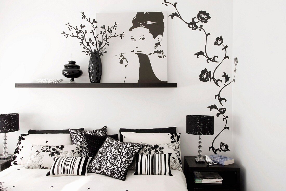 Doppelbett mit femininer schwarzweisser Wanddeko und Fotobild von Audrey Hepburn