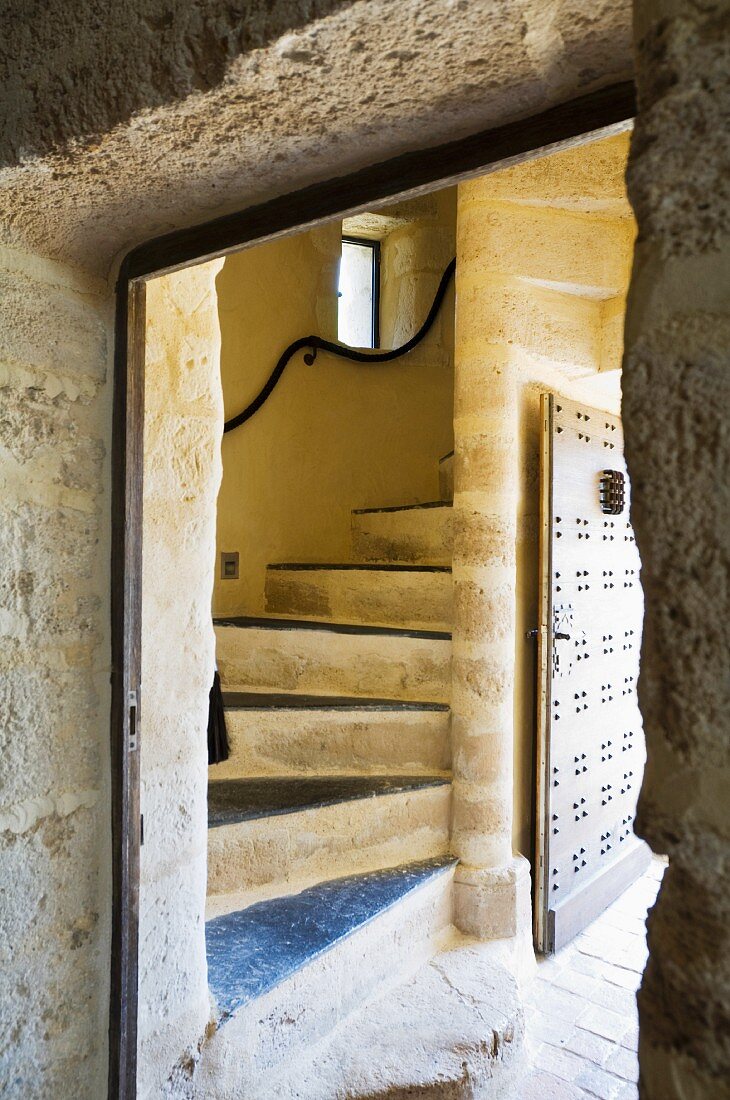 View through doorway of winding stone staircase in rustic house