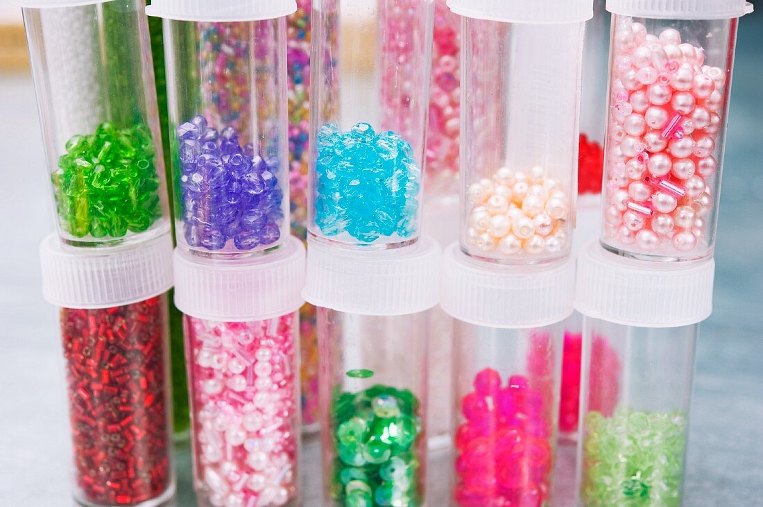 Assorted decorative beads and sequins in plastic tubes