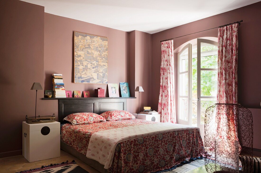 Bedroom with red toile curtains by Oka and bold patterened rugs by Designers Guild