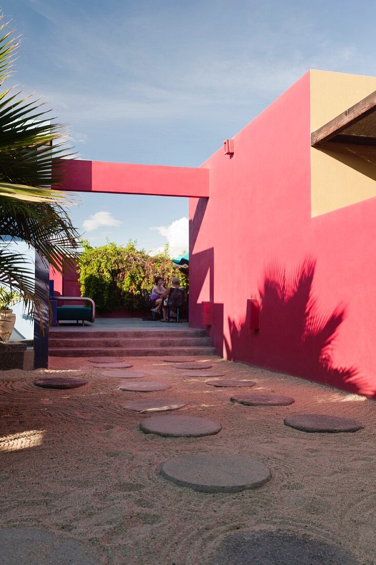 Innenhof des Hotelito mit runden Pflastersteinen und rosa Wänden