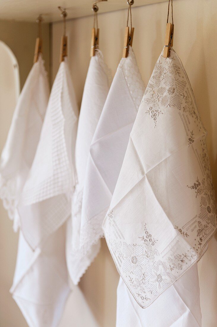 weiße Baumwolltaschentücher an Wäscheklammern hängend