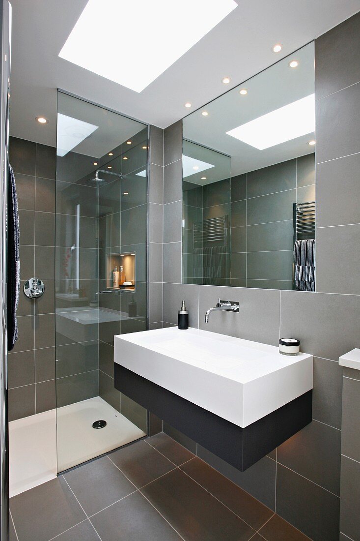 Designer bathroom with gray tiles and embedded lighting in a suspended ceiling