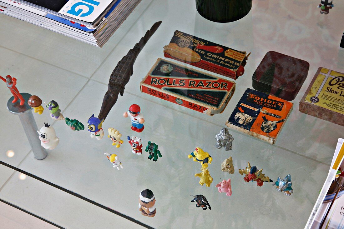 Kleine Spielzeugfiguren auf Glastisch in Reihe aufgestellt
