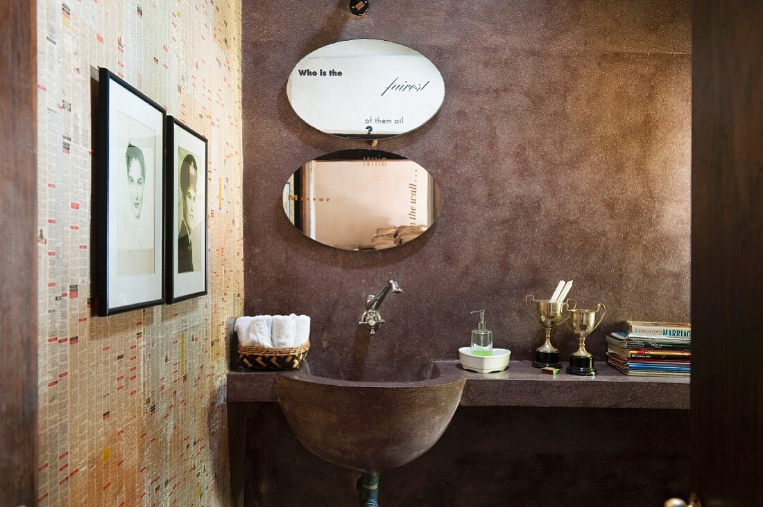 Masonry washstand with shelf and oval mirror in rustic, minimalist bathroom