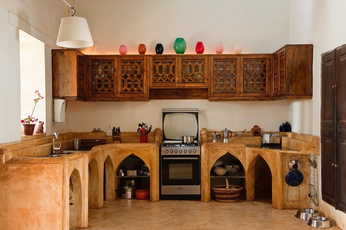 Indian kitchen - masonry kitchen counter with pointed-arch openings in base units and carved wall units