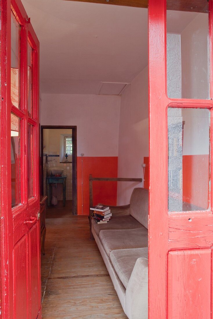 Eingangsbereich in fröhlichem Rot mit samtbezogener Vintage-Couch