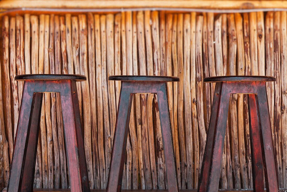 Einfache Bar aus Holz und drei abgenutzte Barhocker in Mexiko