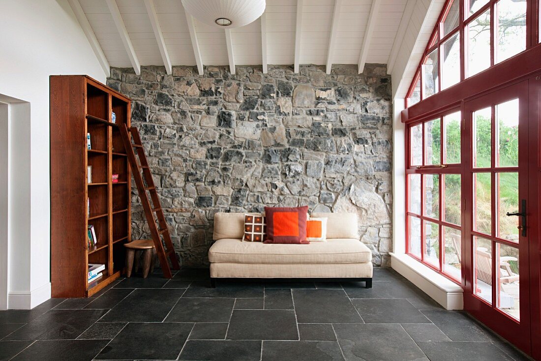 Minimalistisch eingerichtetes Wohnzimmer mit Natursteinwand