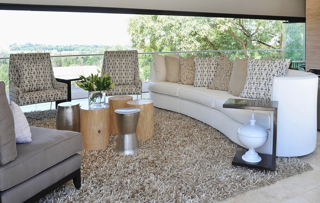Armchairs with patterned upholstery and sofa in front of panoramic window